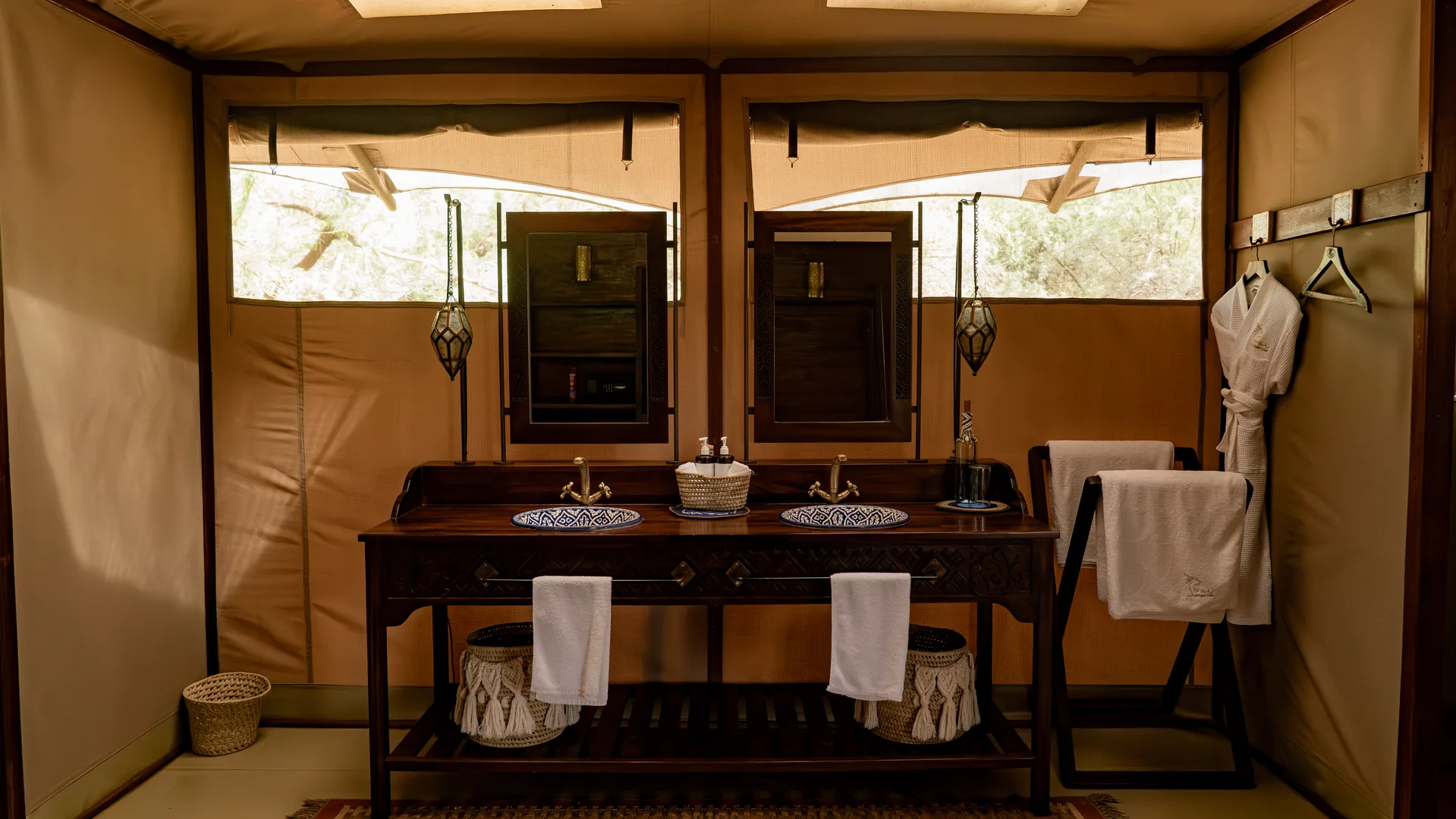 Aus Stein gehauene Badewanne an hohen Fenstern in einer Buschlodge-Suite