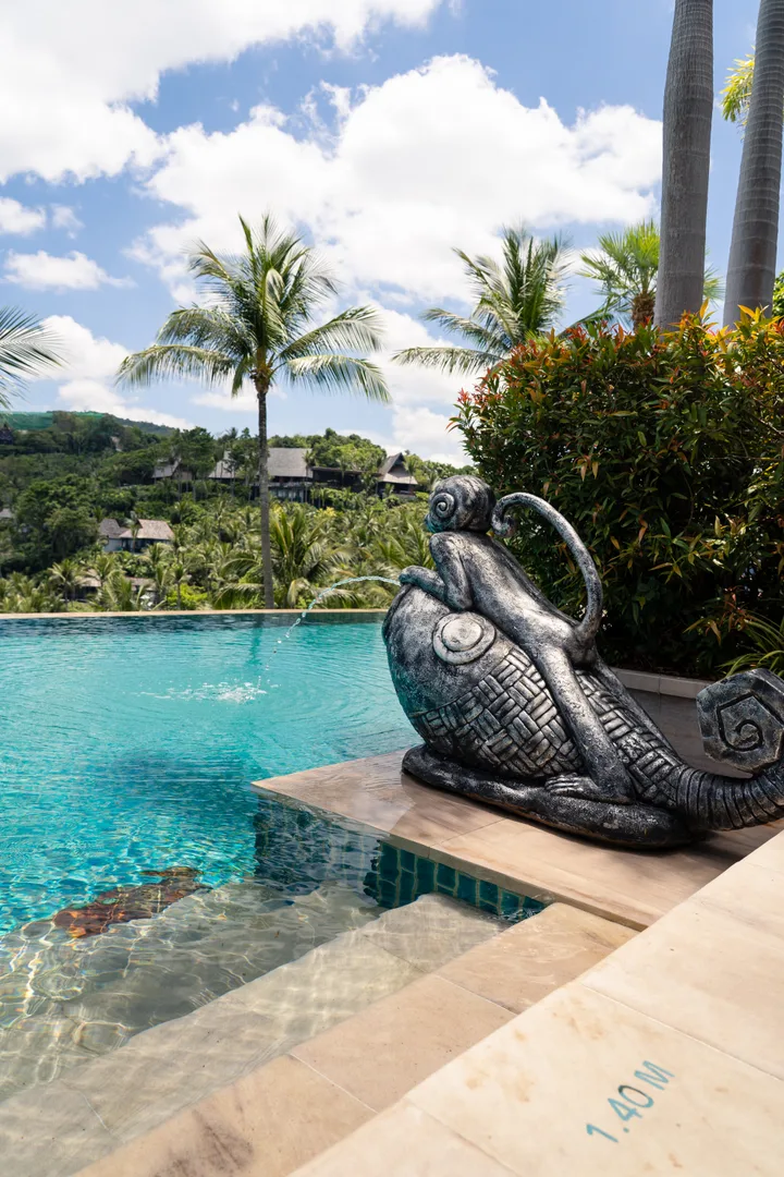 Sculpture au bord de la piscine, jungle et villas en arrière-plan, Koh Samui